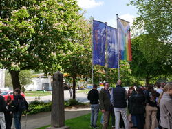 Die Progress Pride Flagge und zwei blaue hochschule 21 Flaggen mit Publikum
