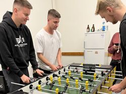 Drei Männer spielen an einem Tischkicker