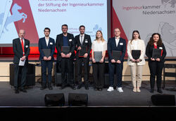 Preisträger:innen mit Urkunde auf der Bühne