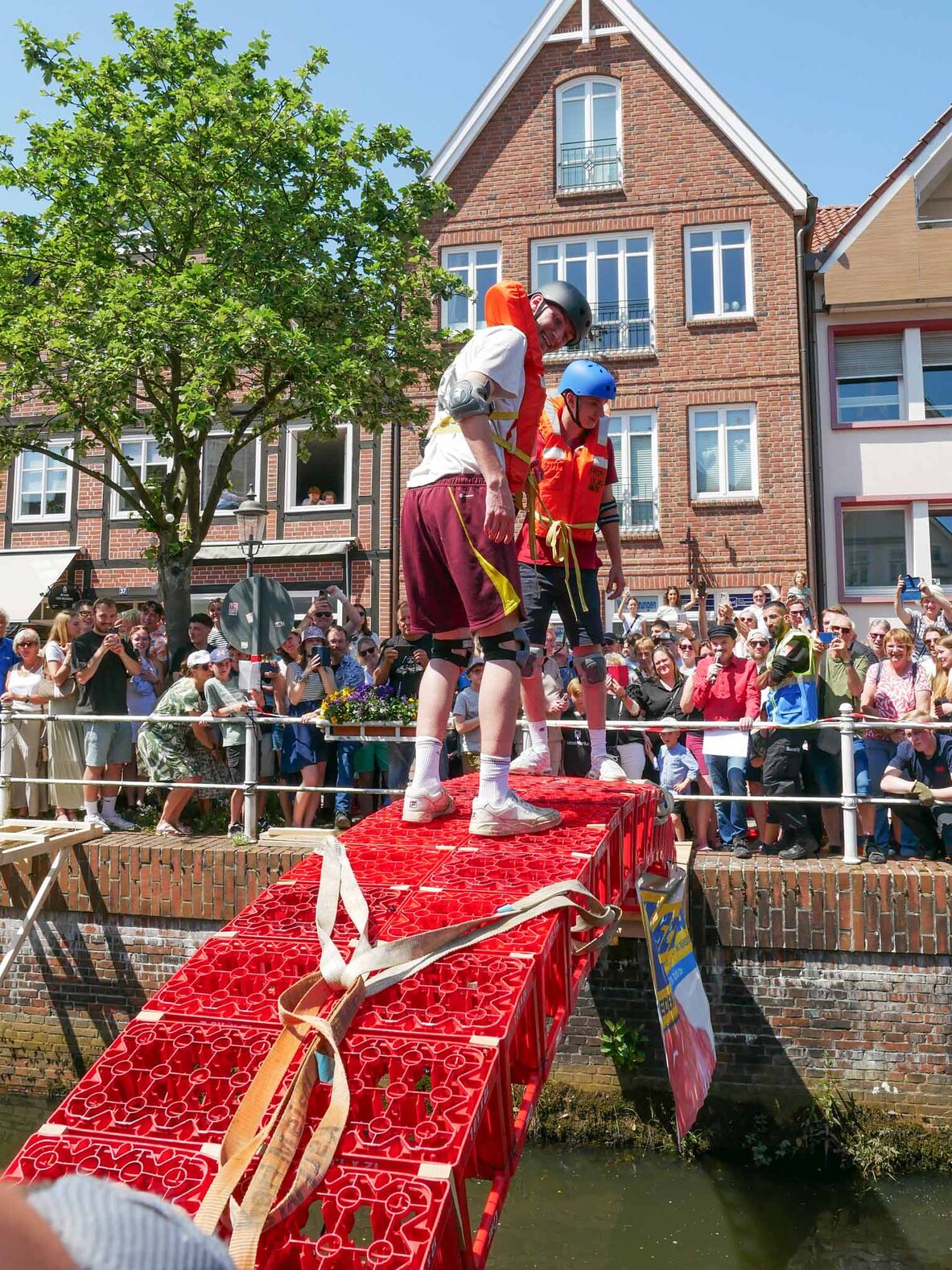 Zwei Studierende besteigen eine Brücke aus Getränkekisten.