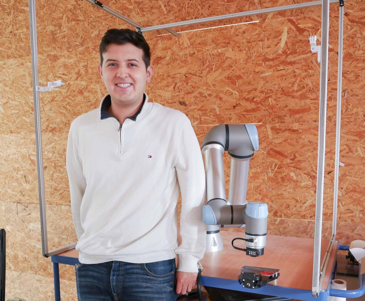 Student Tiam Dominique González Alvarado neben dem Roboterarm