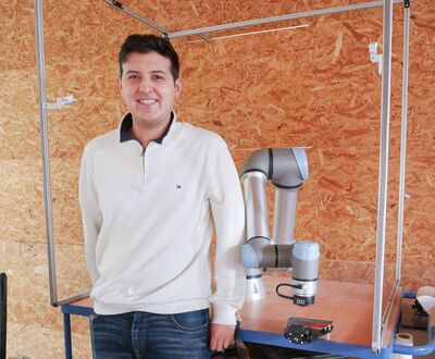 Student Tiam Dominique González Alvarado neben dem Roboterarm